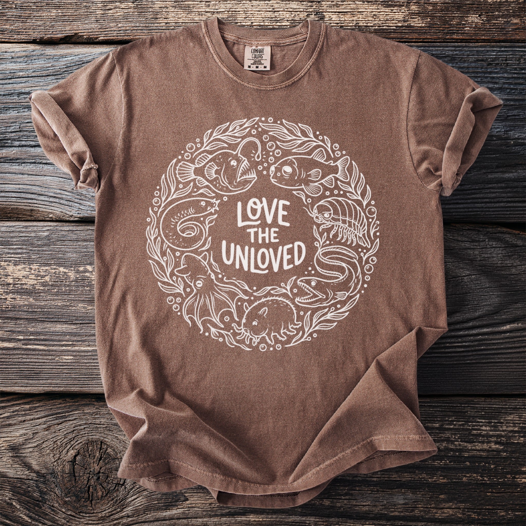 T-shirt with white circular design of sea creatures and text "LOVE THE UNLOVED".