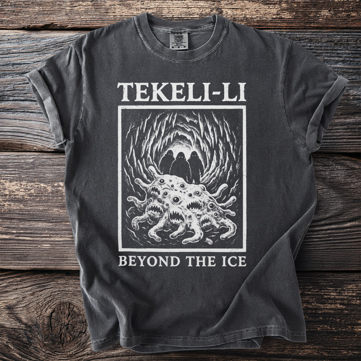 Dark grey t-shirt with a graphic of a monstrous creature and the text "TEKELI-LI BEYOND THE ICE".