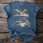 Blue t-shirt with a tan graphic of a frog holding a steaming cup.