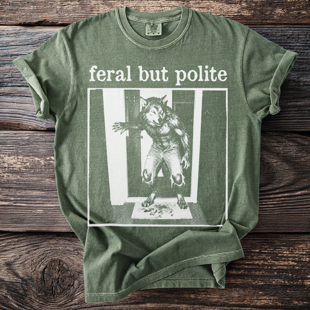 Green t-shirt with "feral but polite" text and werewolf graphic.