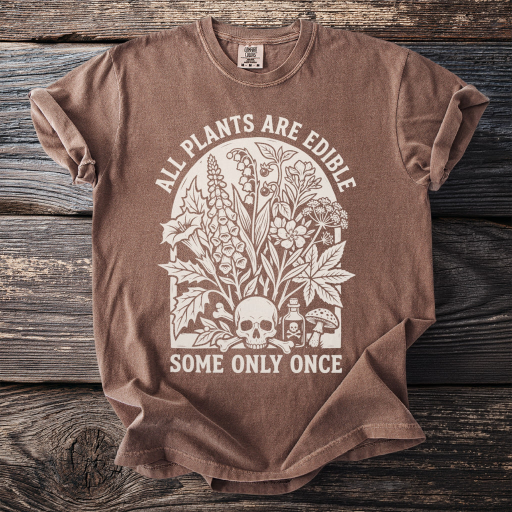 Brown t-shirt with cream graphic featuring plants, skull, poison bottle, and text.