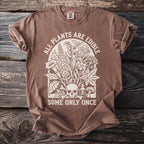 Brown t-shirt with cream graphic featuring plants, skull, poison bottle, and text.