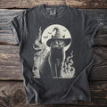 Black cat wearing a witch hat with bats and moon, on a charcoal t-shirt.