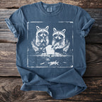 T-shirt with a graphic of two raccoons eating french fries inside a distressed square.