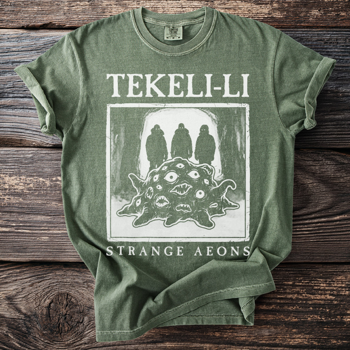 Green t-shirt with "TEKELI-LI STRANGE AEONS" text and a creature with many eyes.