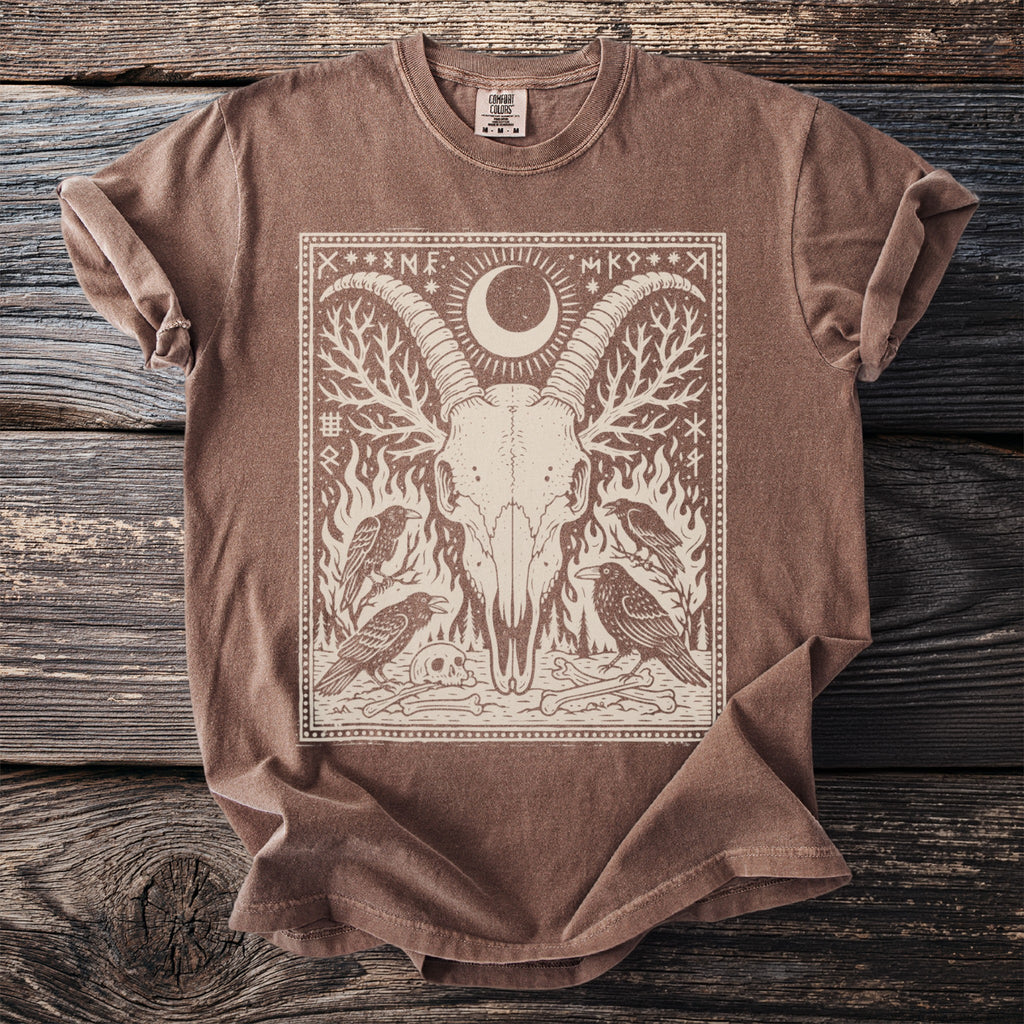 Brown t-shirt with a graphic of a goat skull, ravens, and celestial symbols.