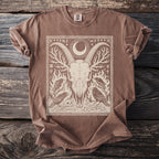 Brown t-shirt with a graphic of a goat skull, ravens, and celestial symbols.