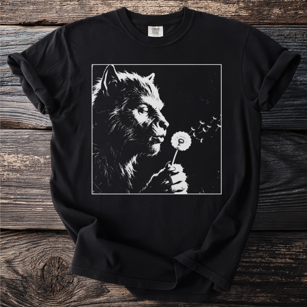 Black t-shirt with a black and white graphic of a werewolf blowing a dandelion.