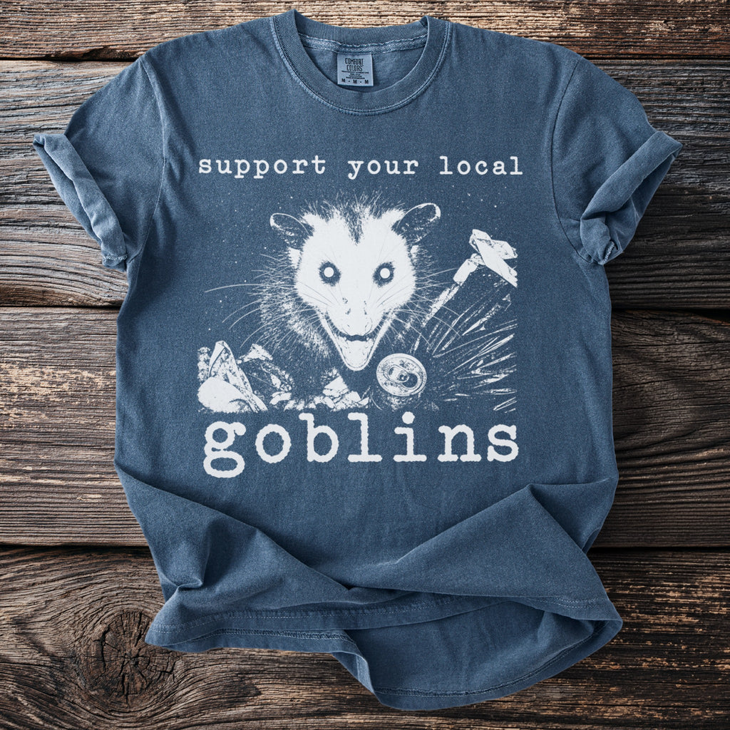 T-shirt with "Support Your Local Goblins" and an opossum graphic.