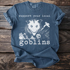 T-shirt with "Support Your Local Goblins" and an opossum graphic.