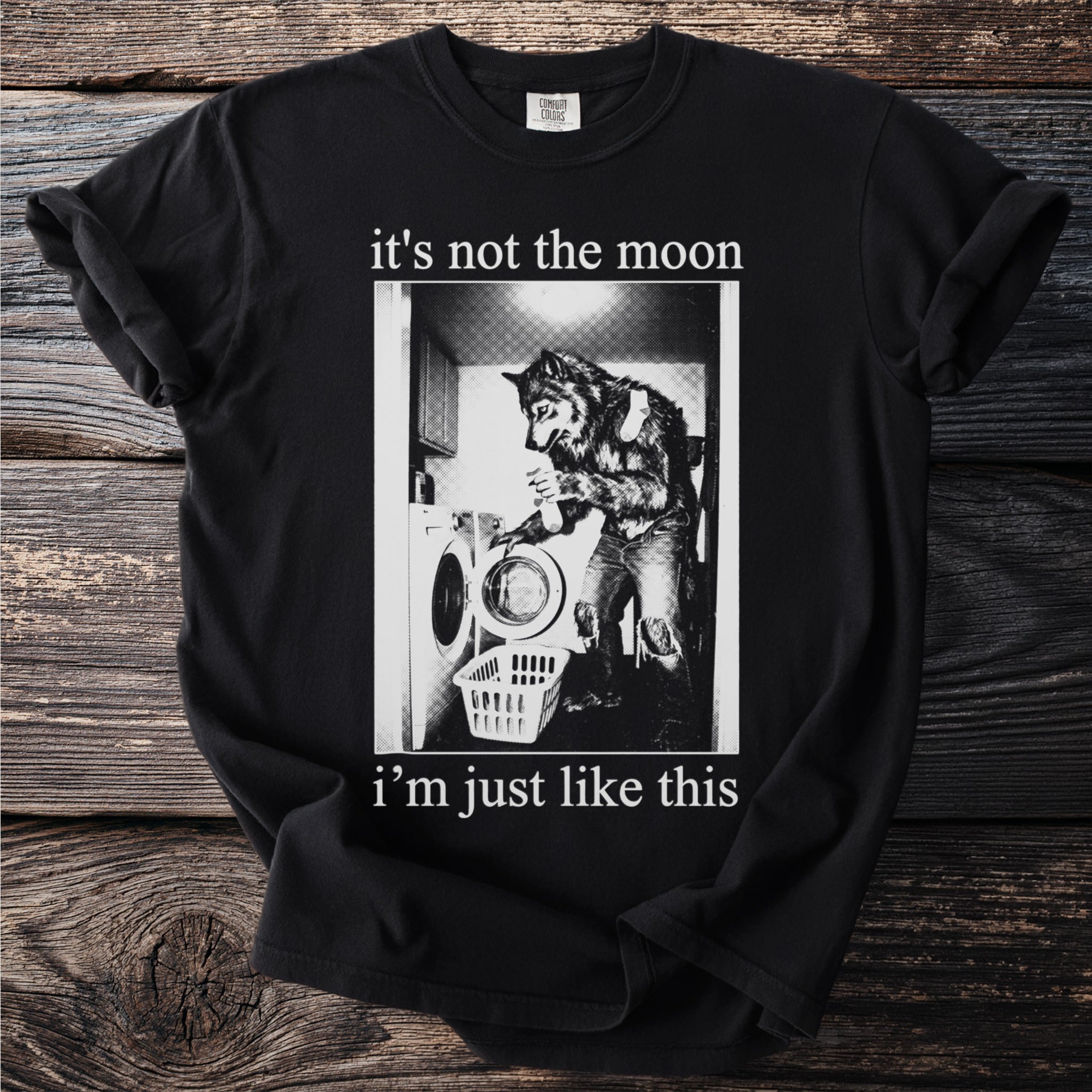 Black t-shirt with a graphic of a werewolf doing laundry and text "it's not the moon i'm just like this".