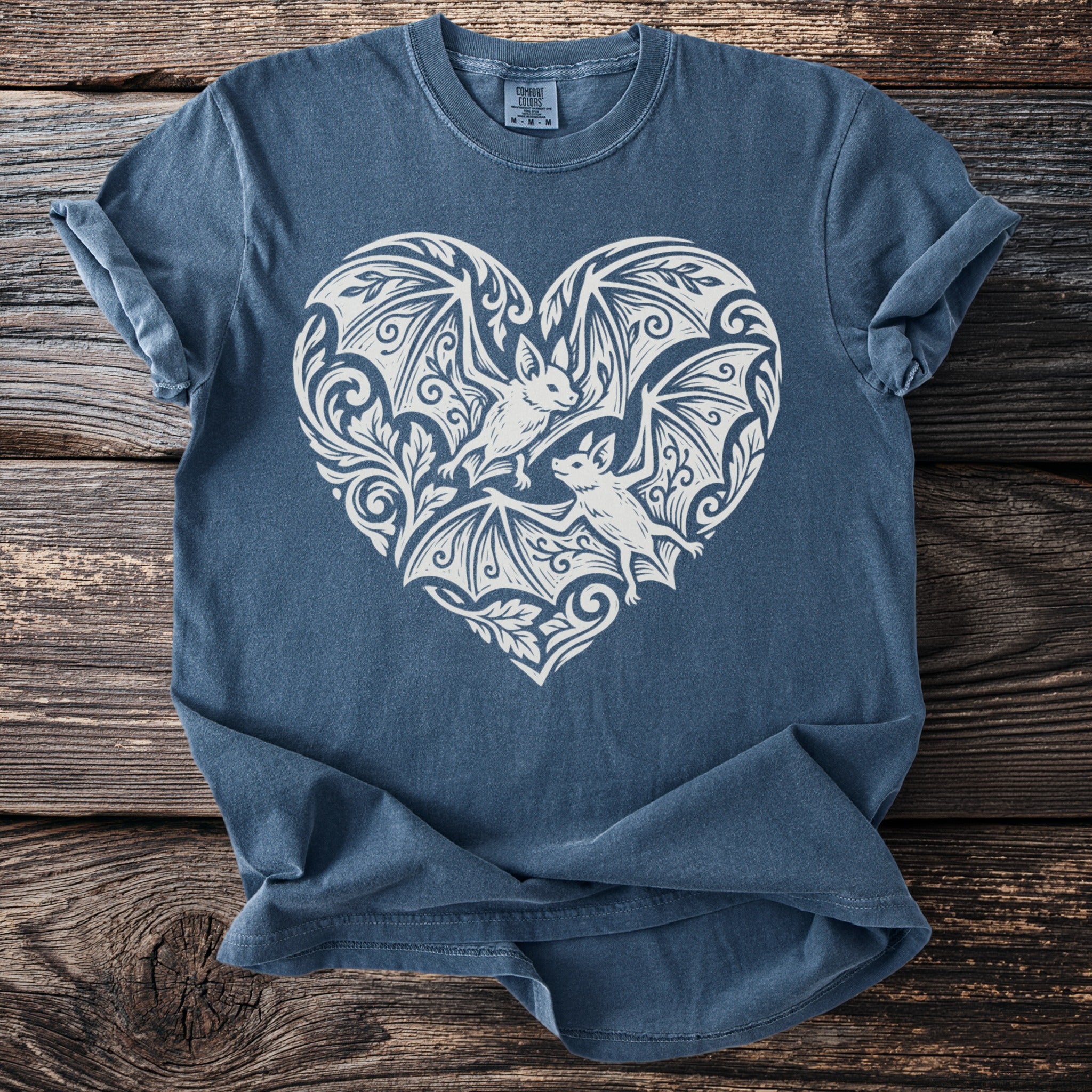 Blue t-shirt with white heart design featuring two bats and ornate floral accents.