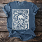 Blue t-shirt with skull, crossed bones, flowers, and text "ALL PLANTS ARE EDIBLE SOME ONLY ONCE".