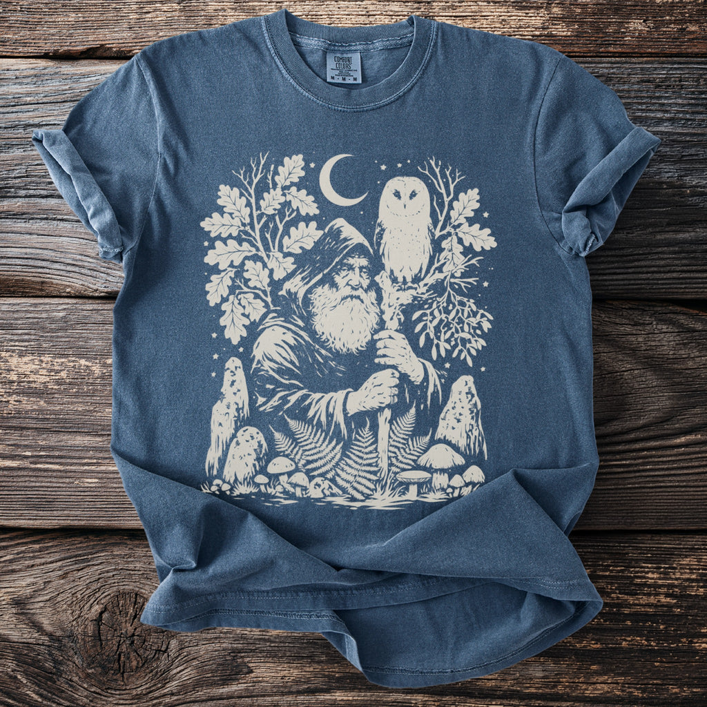 Blue t-shirt with a cream graphic of a wizard, owl, moon, and forest elements.