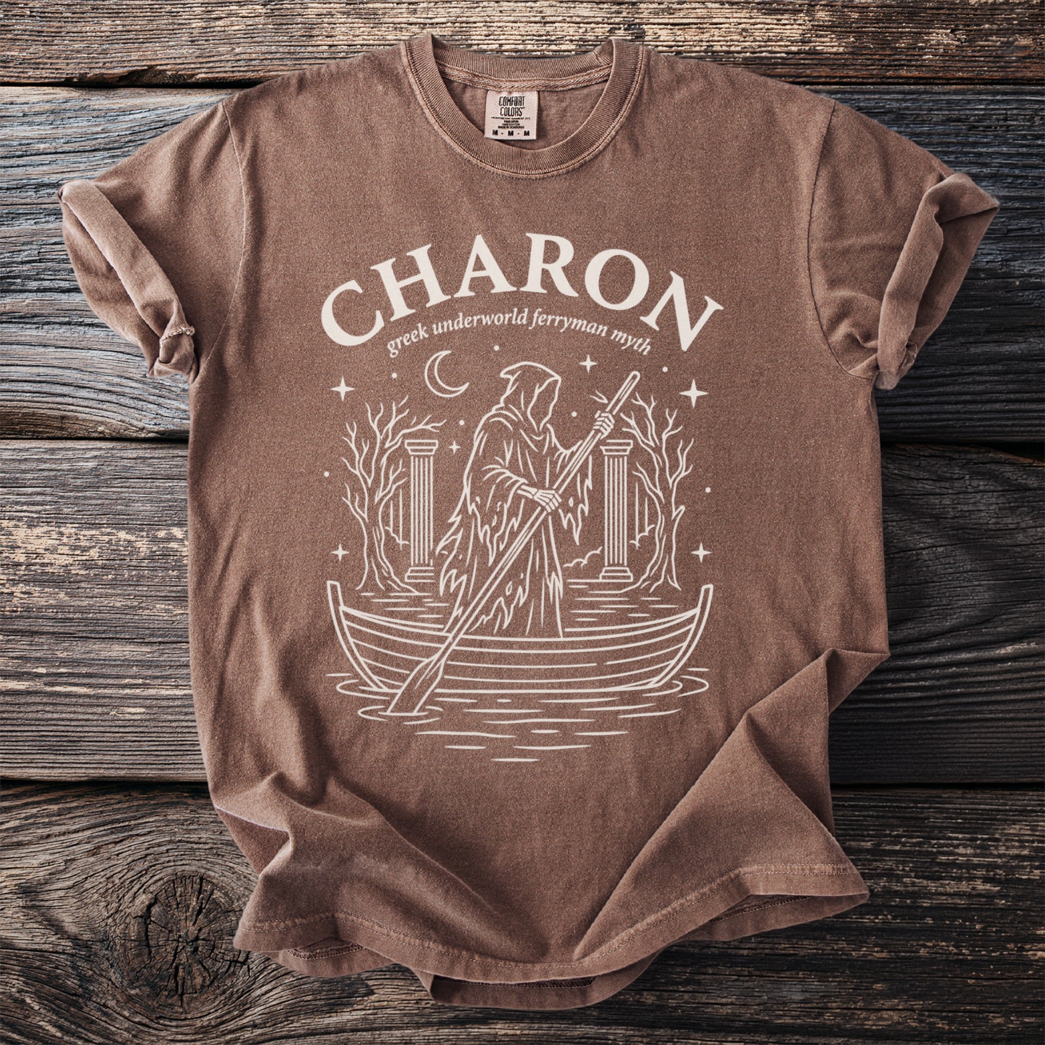 Brown t-shirt with white graphic of Charon, Greek underworld ferryman, in a boat.