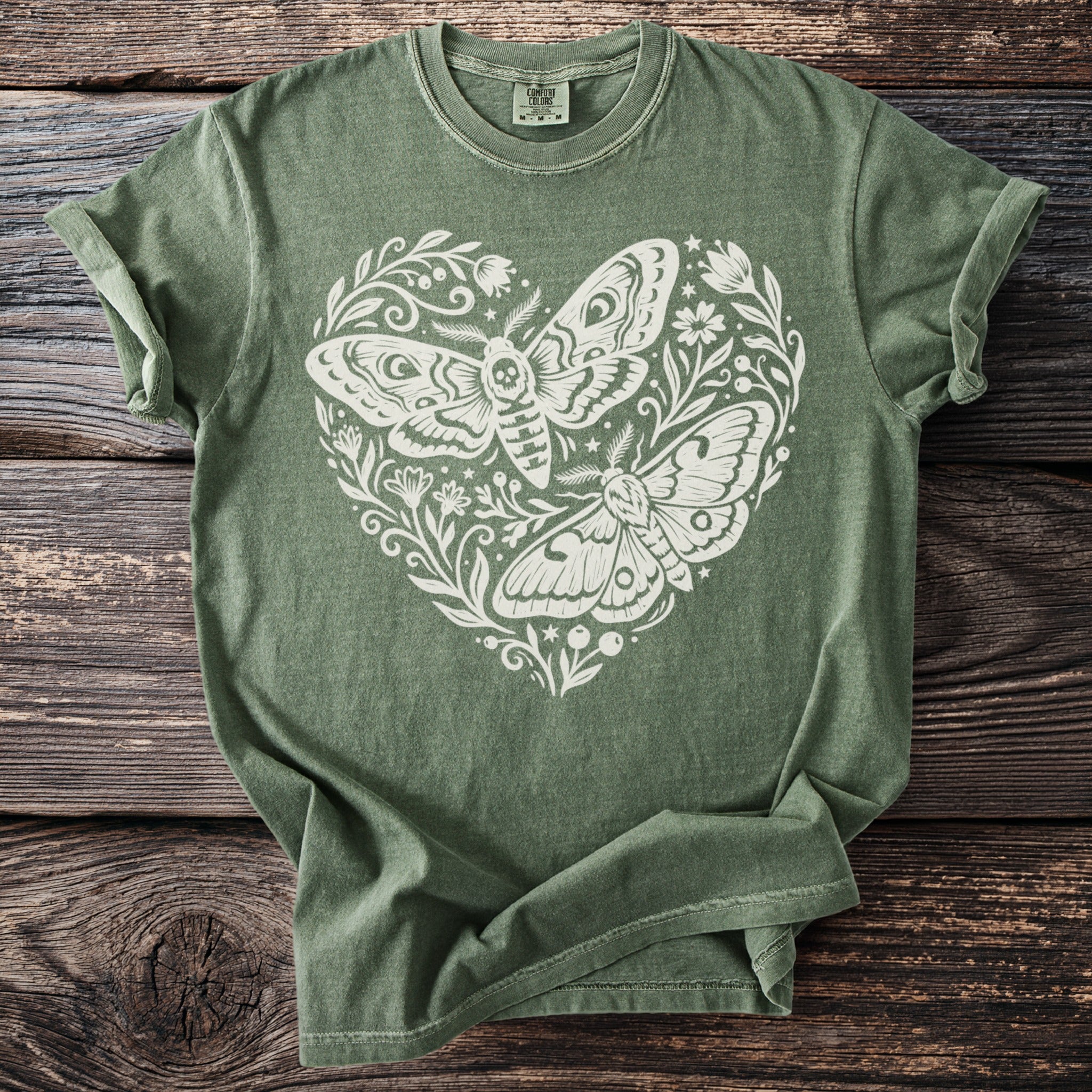 Green t-shirt with white heart design of two moths and floral accents