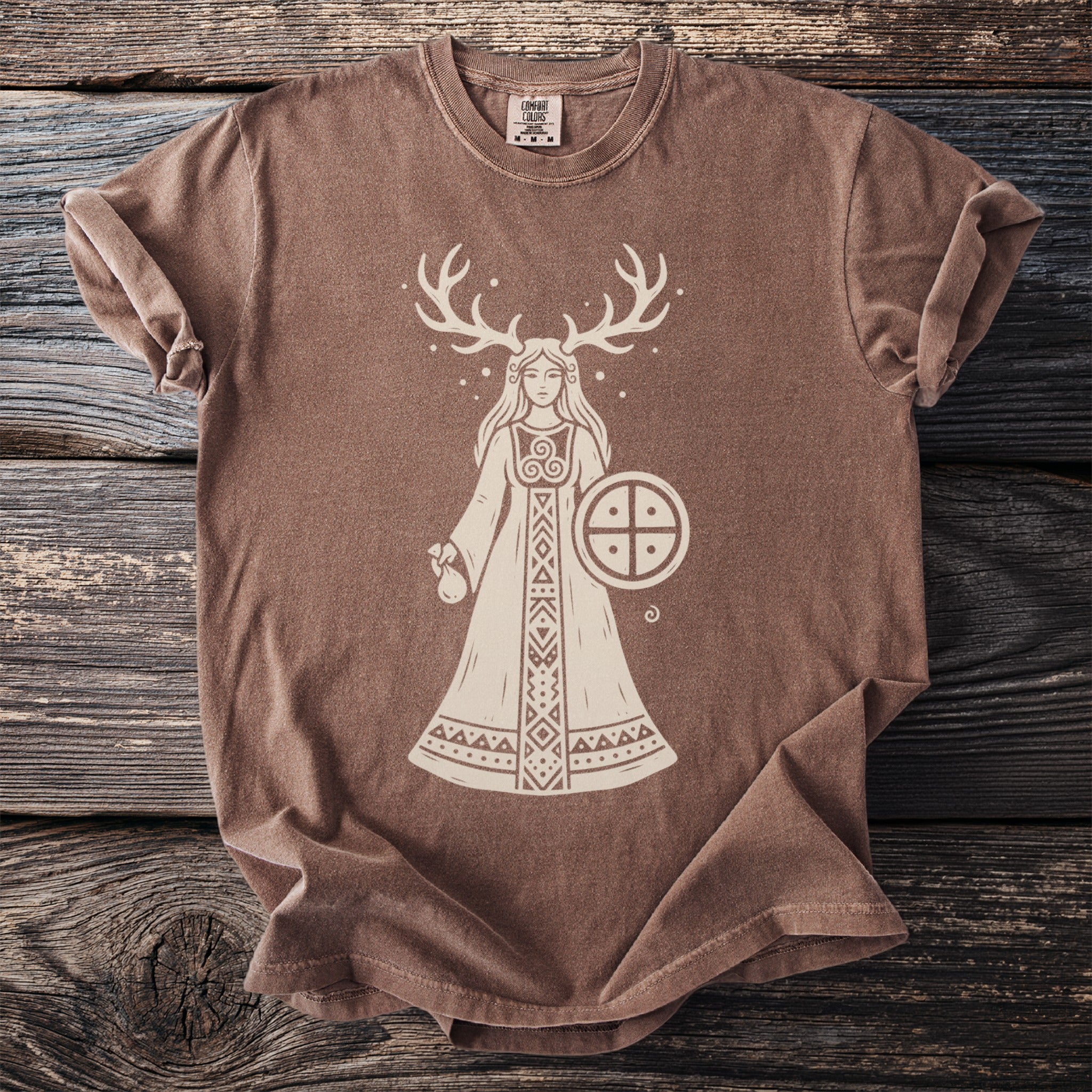 Brown t-shirt with a graphic of a woman with antlers holding a shield.
