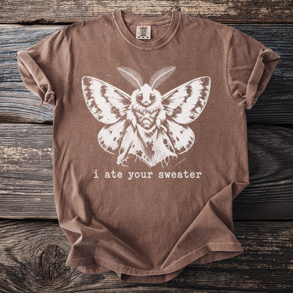 Brown t-shirt with white moth graphic and text "i ate your sweater".