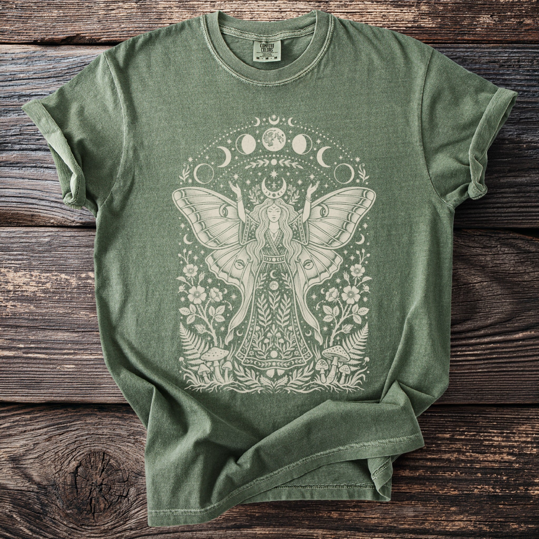 Green t-shirt with mystical moth woman, moon phases, and floral design.