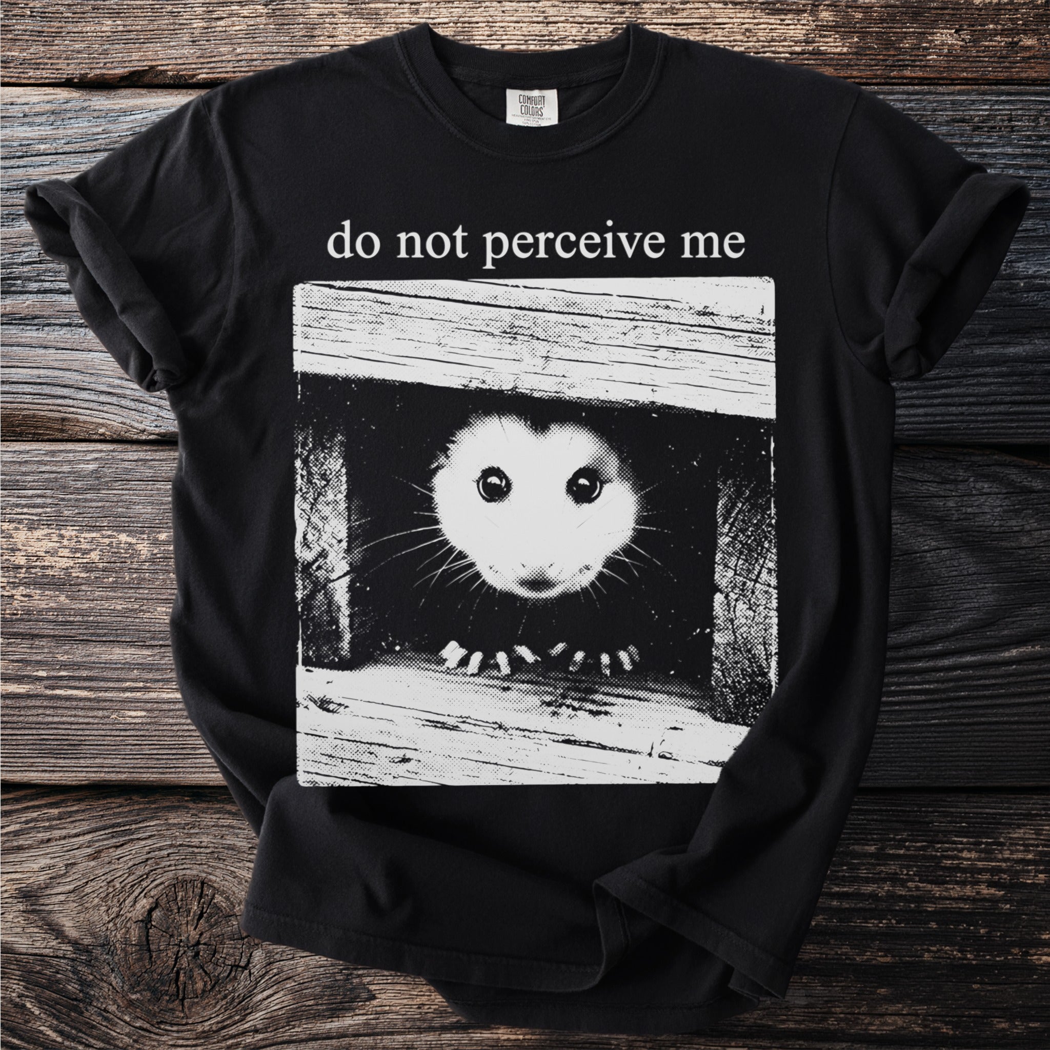 Black t-shirt front graphic with possum peeking out and text "do not perceive me".