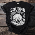 Black t-shirt with "SQUONK" text and a white illustration of a sad, leaky dog.