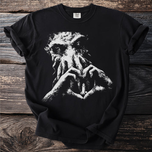 Black t-shirt with Cthulhu illustration making heart shape around lighthouse.