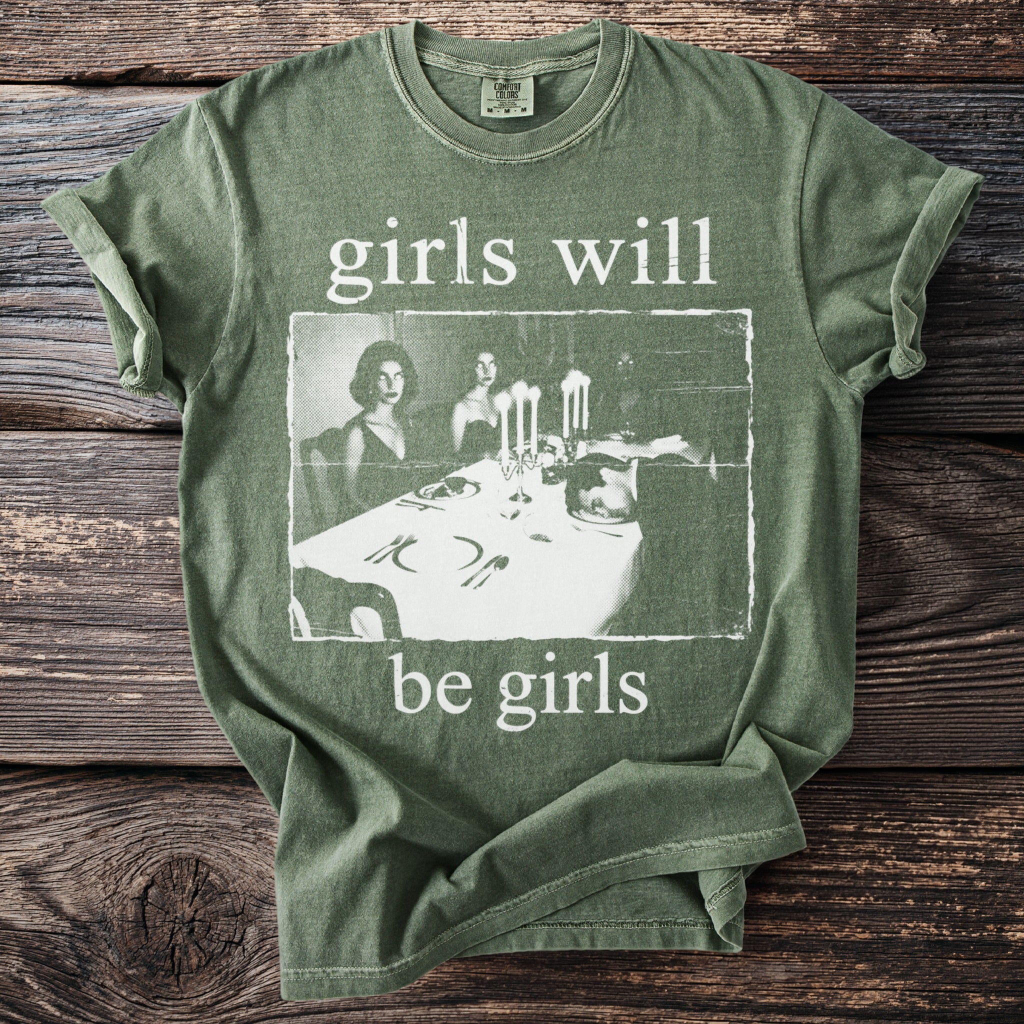 Green t-shirt with white text "girls will be girls" and a vintage image.