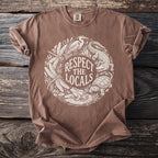 Brown t-shirt with white circular graphic of local wildlife and text "Respect the Locals."