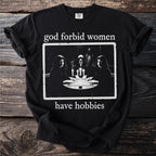 Black t-shirt with text "god forbid women have hobbies" and a gothic image.