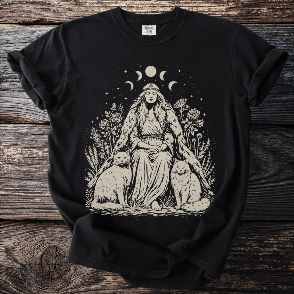 T-shirt with a witch-like woman sitting between two cats with moon phases above.