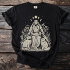 T-shirt with a witch-like woman sitting between two cats with moon phases above.