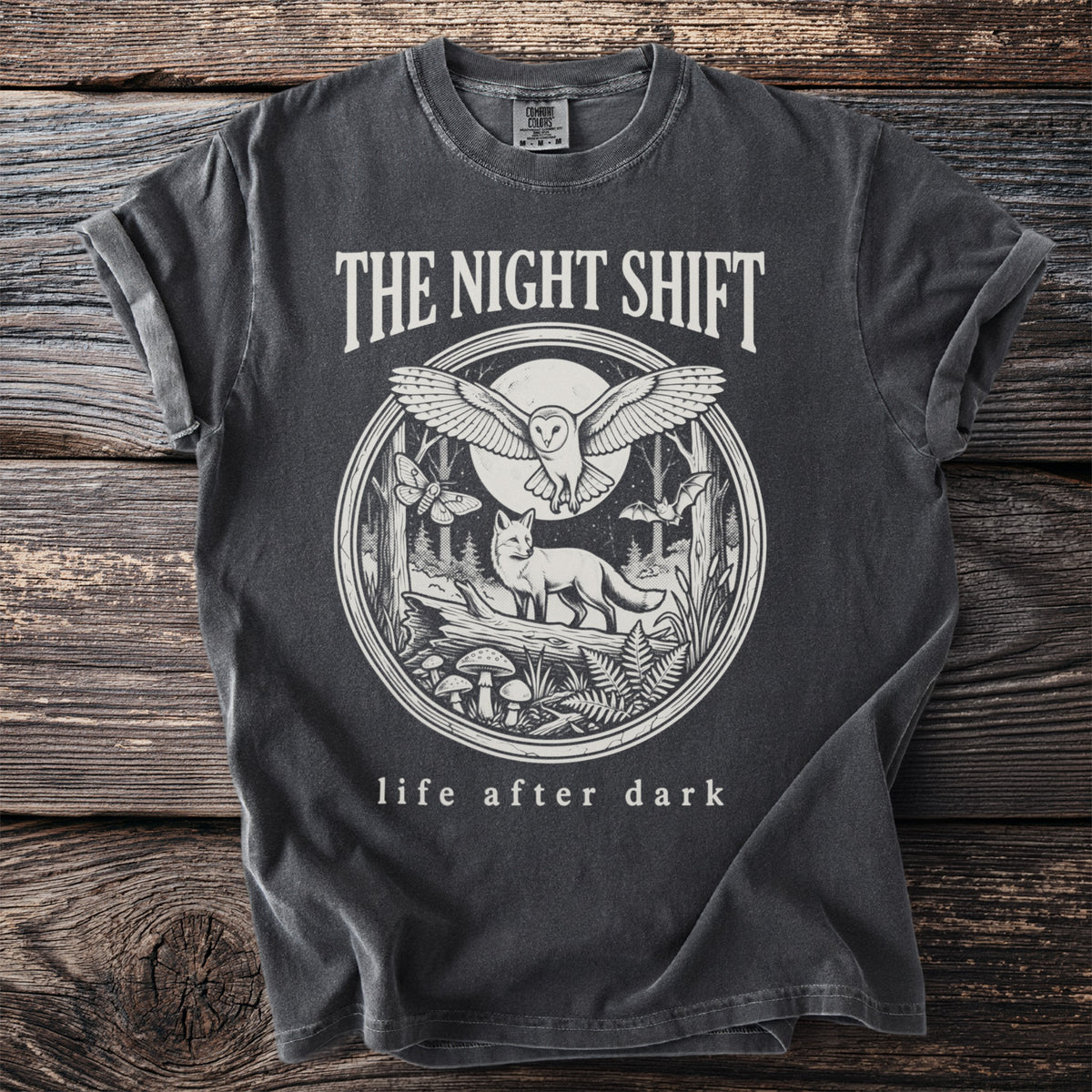Charcoal t-shirt with "The Night Shift" and a circular forest scene with animals.