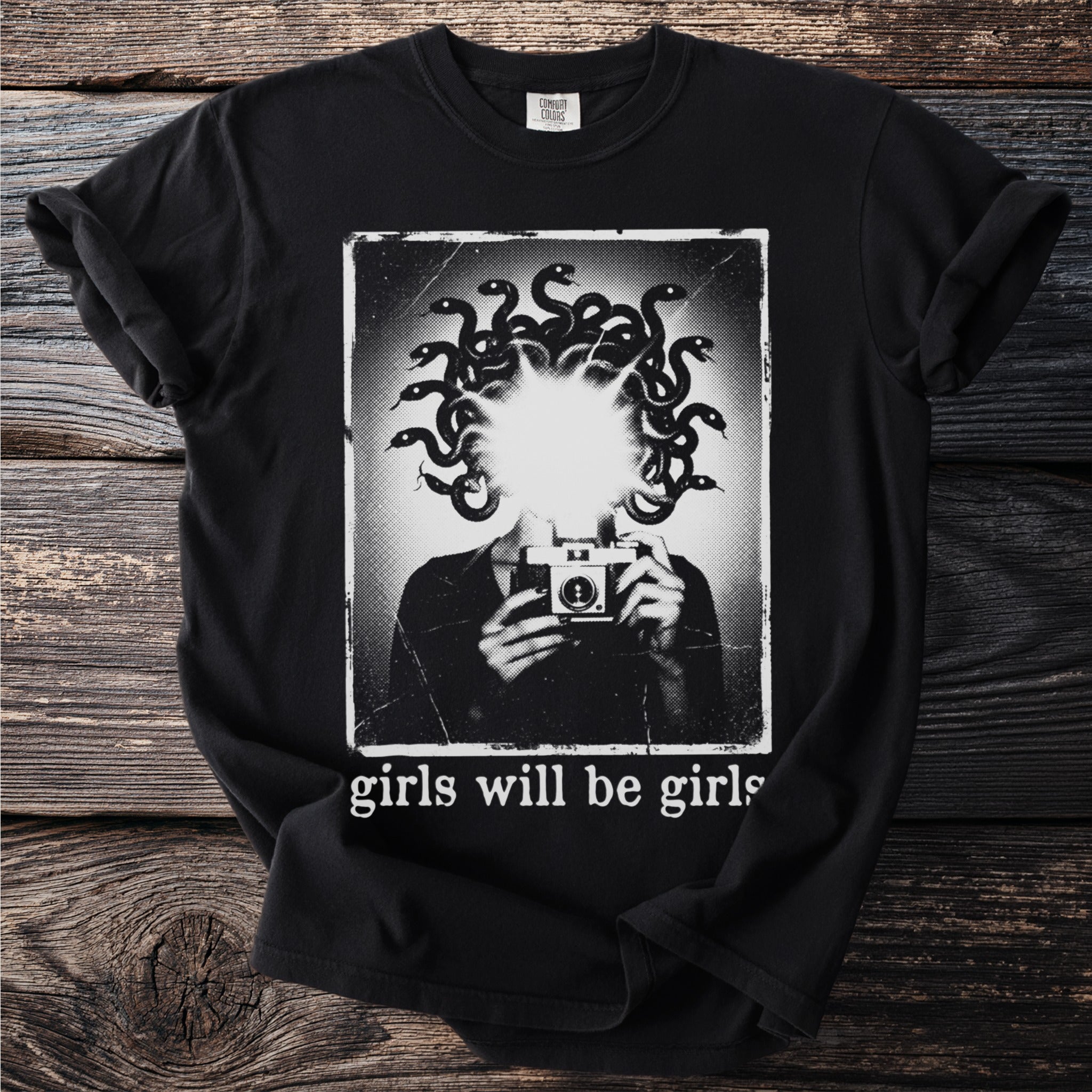 Black t-shirt with graphic of Medusa holding a camera and text "girls will be girls".