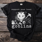 Black t-shirt with possum and trash graphic reading "support your local goblins."
