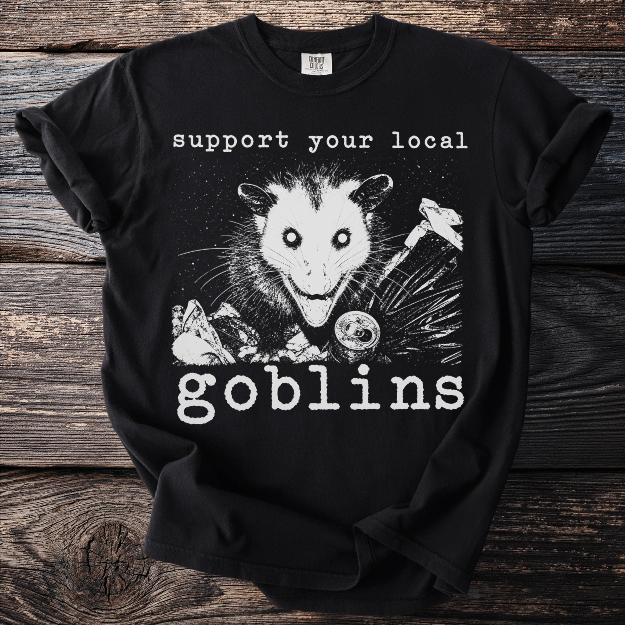 Black t-shirt with possum and trash graphic reading "support your local goblins."