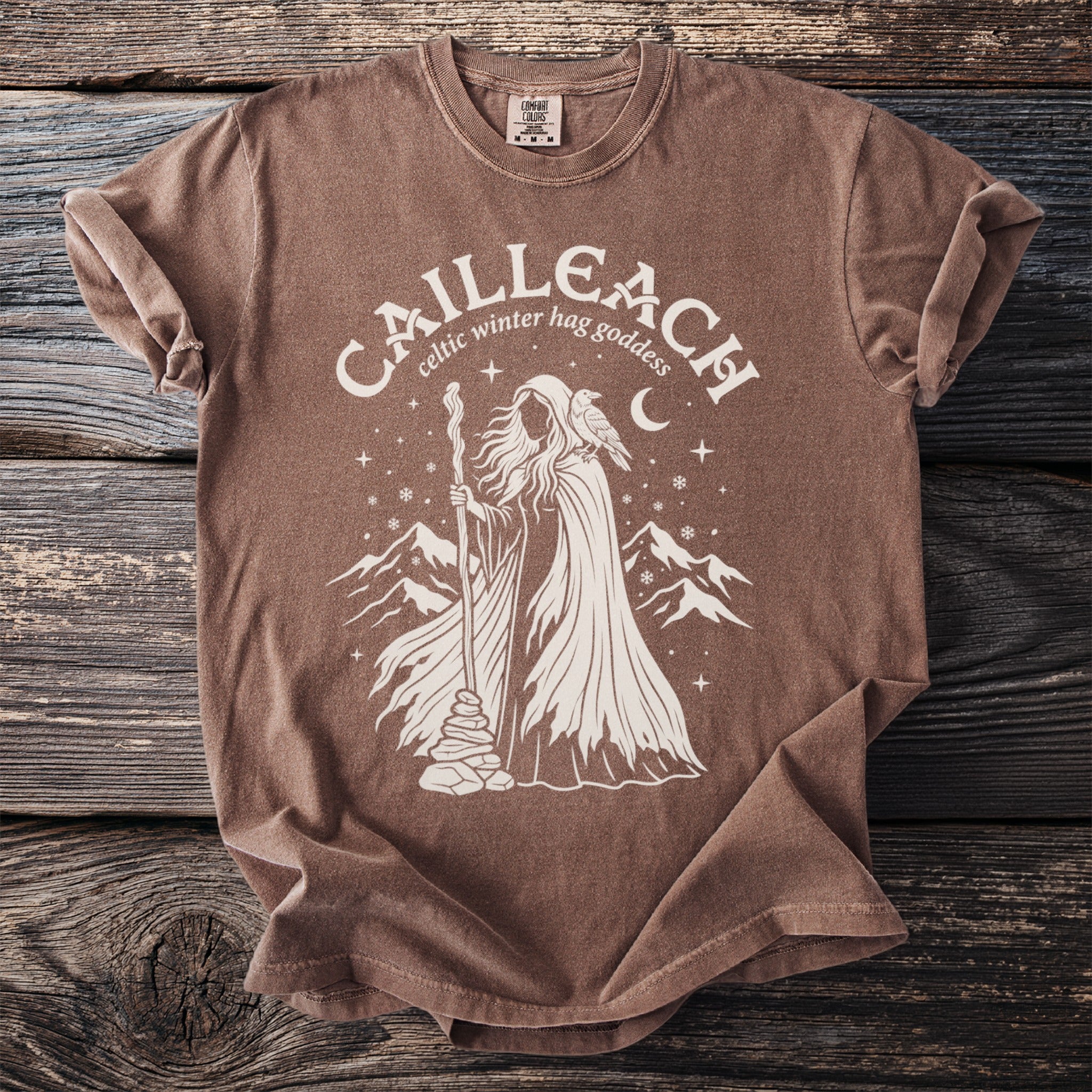Brown t-shirt with white graphic of Cailleach, Celtic winter hag goddess.