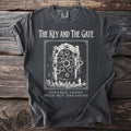 Dark gray t-shirt with white text and graphic: "The Key and The Gate" and "Strange Aeons Dead But Dreaming".