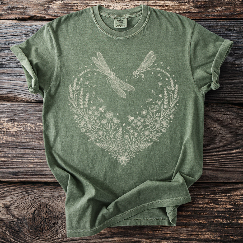 Green t-shirt with a white linework design of dragonflies and a floral heart.