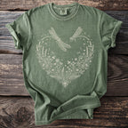 Green t-shirt with a white linework design of dragonflies and a floral heart.