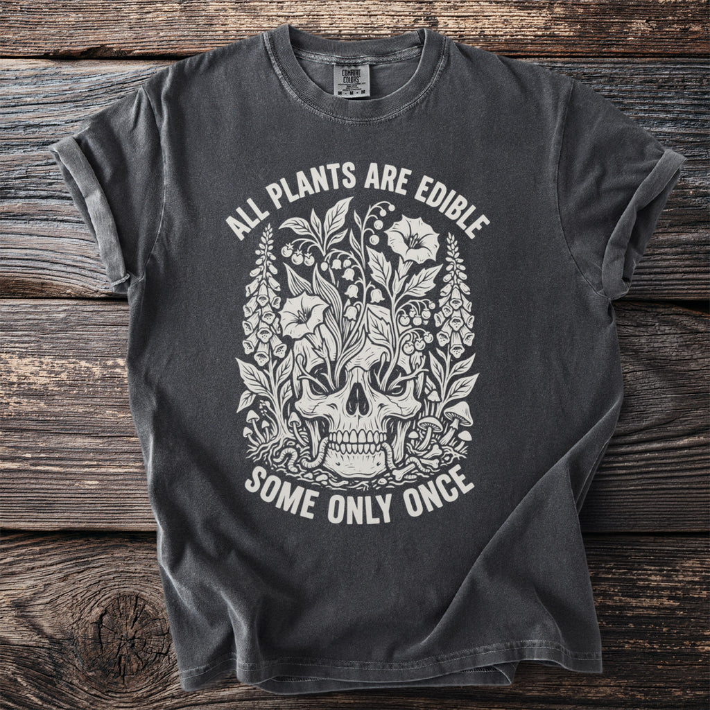 Dark gray t-shirt with skull and floral graphic, reading "All Plants Are Edible, Some Only Once."