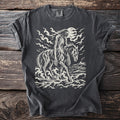Pepper gray t-shirt with a cream linocut of the Nuckelavee, the skinless horse and rider of Scottish sea folklore, coming ashore toward a lone croft.
