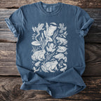 Blue t-shirt with white line art illustration of various frogs and tadpoles.