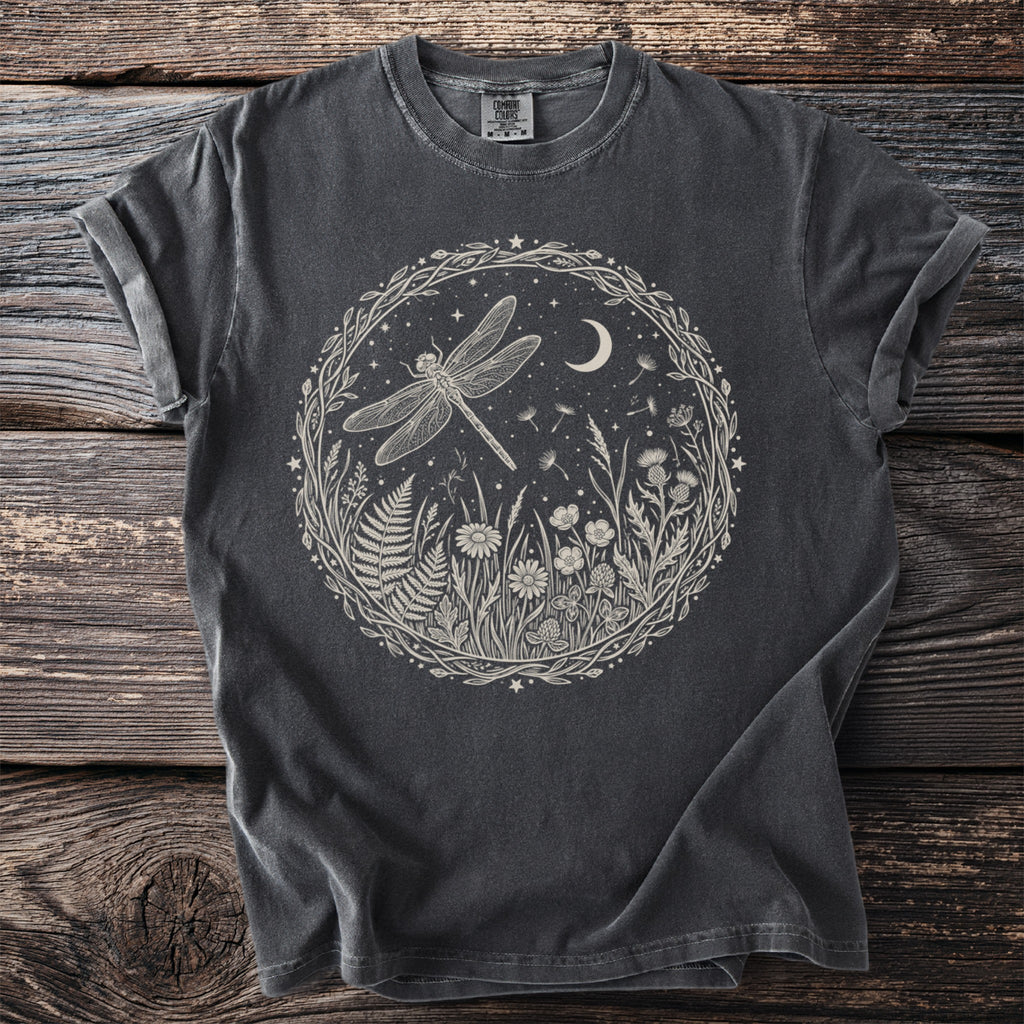 Dark grey t-shirt with a circular design of a dragonfly, moon, stars, and wildflowers.