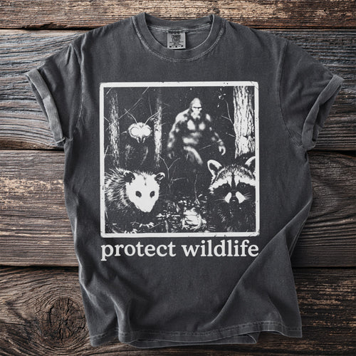 Charcoal t-shirt with graphic of Bigfoot, possum, raccoon, and moth with "protect wildlife" text.