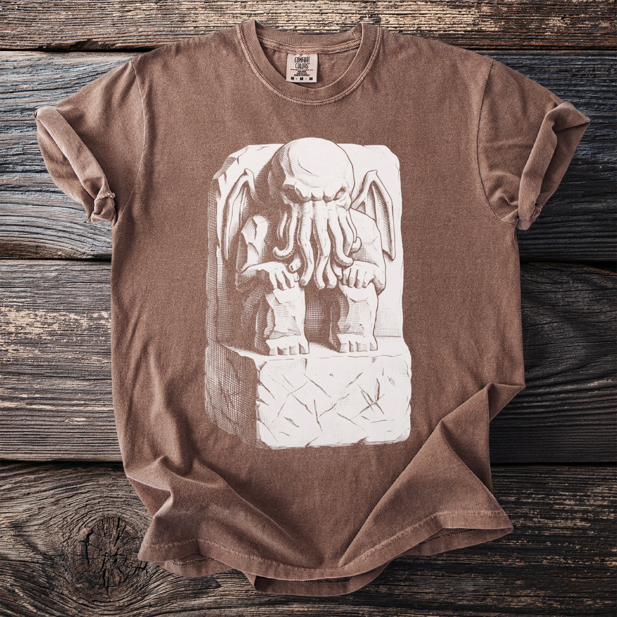 Brown t-shirt with a white relief carving of a tentacled creature.