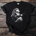Black t-shirt with Bigfoot blowing dandelion seeds graphic.