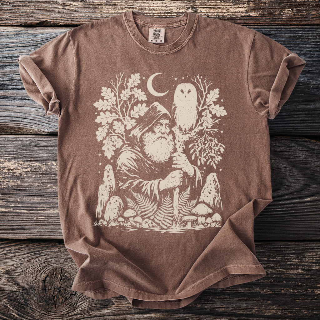 Brown t-shirt with a mystical forest graphic featuring a wizard, owl, moon, and mushrooms.