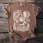 Brown t-shirt with a mystical forest graphic featuring a wizard, owl, moon, and mushrooms.
