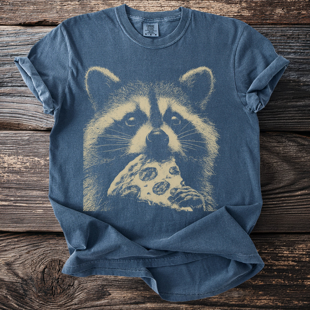 Blue t-shirt with a beige graphic of a raccoon eating pizza.