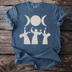 Blue t-shirt with triple moon and three figures dancing graphic print.